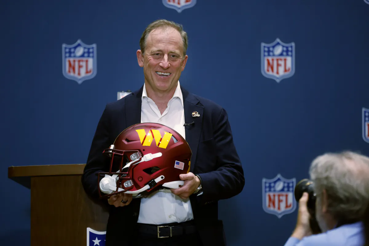 Josh Harris, leader of a group buying the Washington Commanders, poses with a team helmet after NFL owners voted to approve the sale in Bloomington, Minn., on July 20, 2023. (Bruce Kluckhohn/AP Photo)