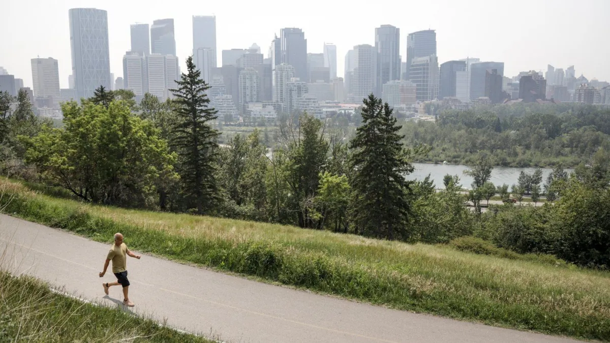 A pedestrian walks in Calgary on July 15, 2021. (The Canadian Press/Jeff McIntosh)
