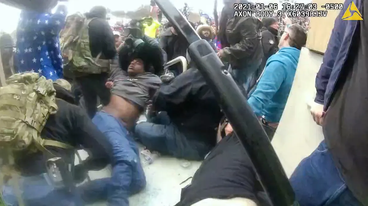 Protester Philip Anderson is pulled out from under a pile of bodies at the mouth of the Lower West Terrace tunnel on Jan. 6, 2021. (Metropolitan Police Department/Screenshot via The Epoch Times)