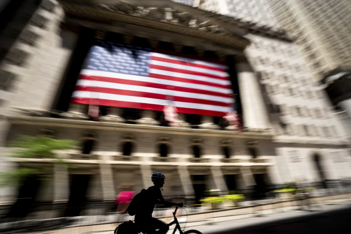 A person bikes past the New York Stock Exchange in New York on June 29, 2022. (Julia Nikhinson/AP Photo)