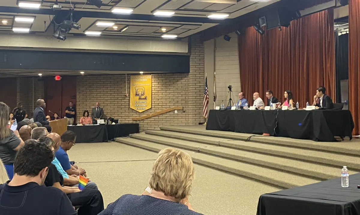 California State Superintendent of Public Instruction Tony Thurmond (L) speaks as a public commenter at a Chino Valley Unified School District meeting in Chino, Calif., on July 20, 2023. (Micaela Ricaforte/The Epoch Times)