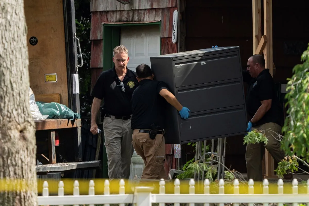 New York State police officers move a metal cabinet as law enforcement searches the home of suspected serial killer Rex Heuermann, in Massapequa Park, N.Y., on July 15, 2023.   (Jeenah Moon/AP Photo)
