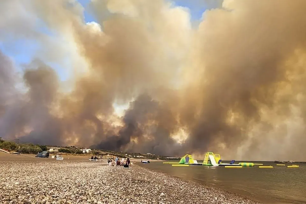 Clouds of smoke from a forest fire rise to the sky on the island of Rhodes, Greece, on July 22, 2023. (Rhodes.Rodos via AP)