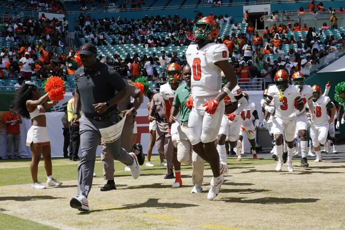 Florida A&M head coach Willie Simmons (L) runs onto the field before the Orange Blossom Classic NCAA college football game against Jackson State in Miami Gardens, Fla., on Sept. 4, 2022. (Lynne Sladky/AP Photo)