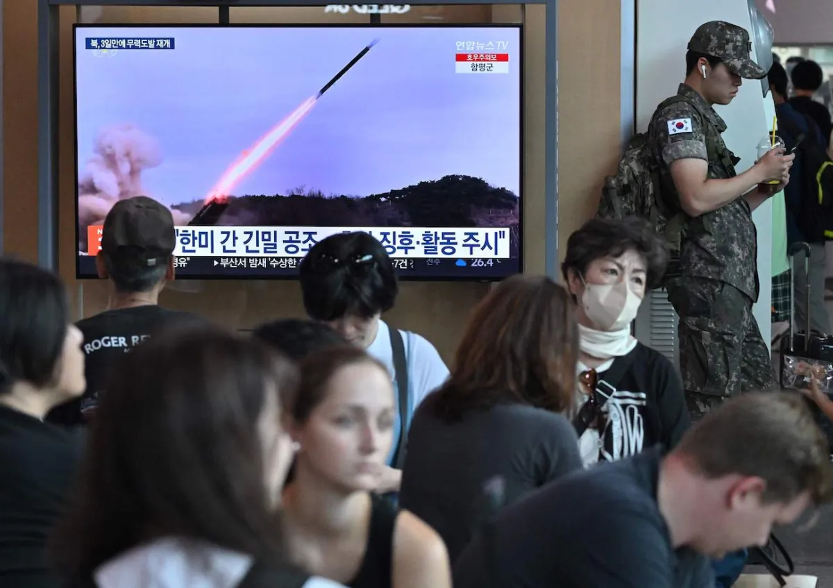 A South Korean soldier (R) stands next to a television screen showing a news broadcast with file footage of a North Korean missile test, at a railway station in Seoul on July 22, 2023. (Jung Yeon-Je/AFP via Getty Images)