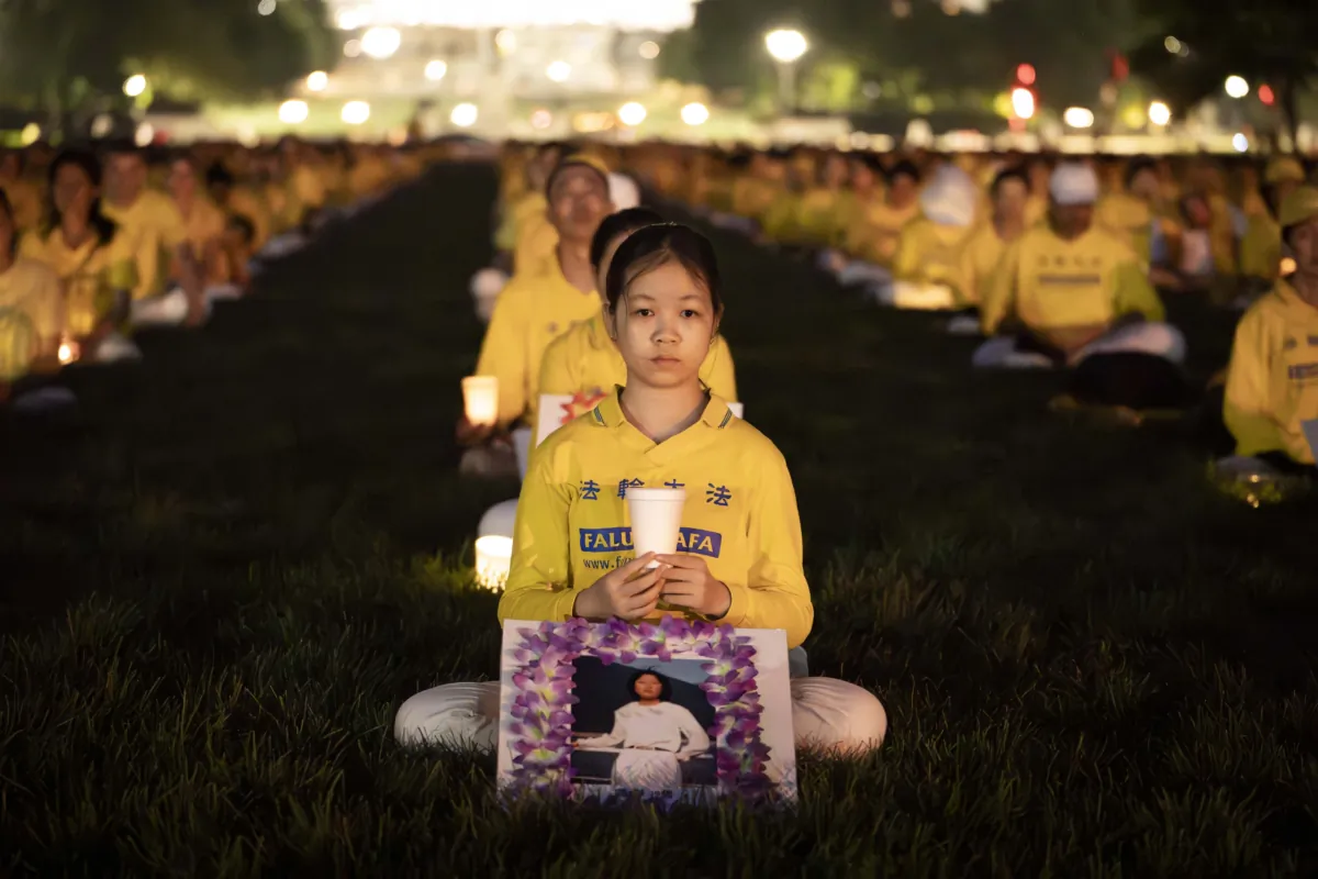 Falun Gong adherents gather at a candlelight vigil in memory of Falun Gong practitioners who passed away due to the Chinese Communist Party's ongoing 24-year persecution of the spiritual discipline, at the National Mall in Washington on July 20, 2023. (Madalina Vasiliu/The Epoch Times)