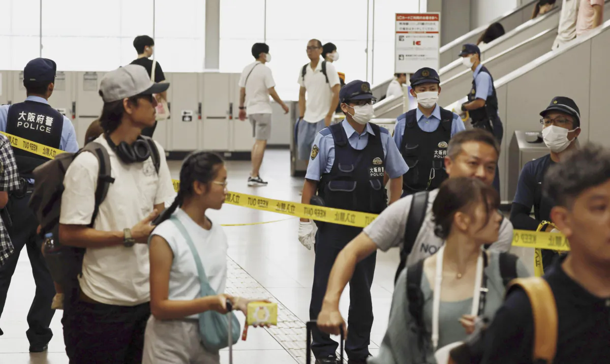 Following an emergency call of a knife attack on a train, Japanese police officers patrol a train station after a man was arrested at the station in Izumisano, south of Osaka, western Japan, on July 24, 2023. (Kenzaburo Fukuhara/Kyodo News via AP)