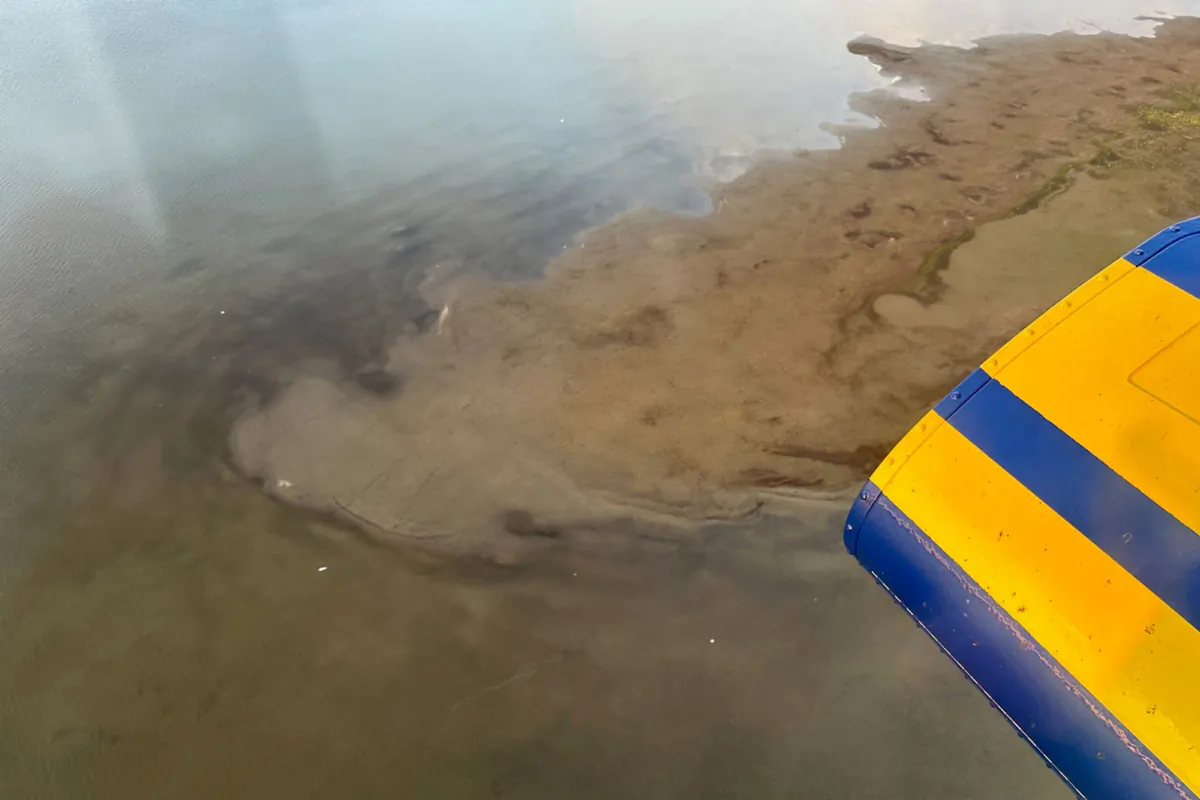 This photo provided by North Slope Borough shows an aerial view of a shallow lake where a helicopter crashed on Alaska's North Slope near Utqiagvik, Alaska, on July 20, 2023. (North Slope Borough via AP)
