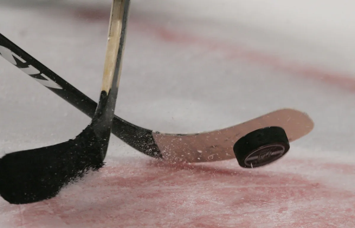 Hockey sticks and puck in a file photo. (Bruce Bennett/Getty Images)