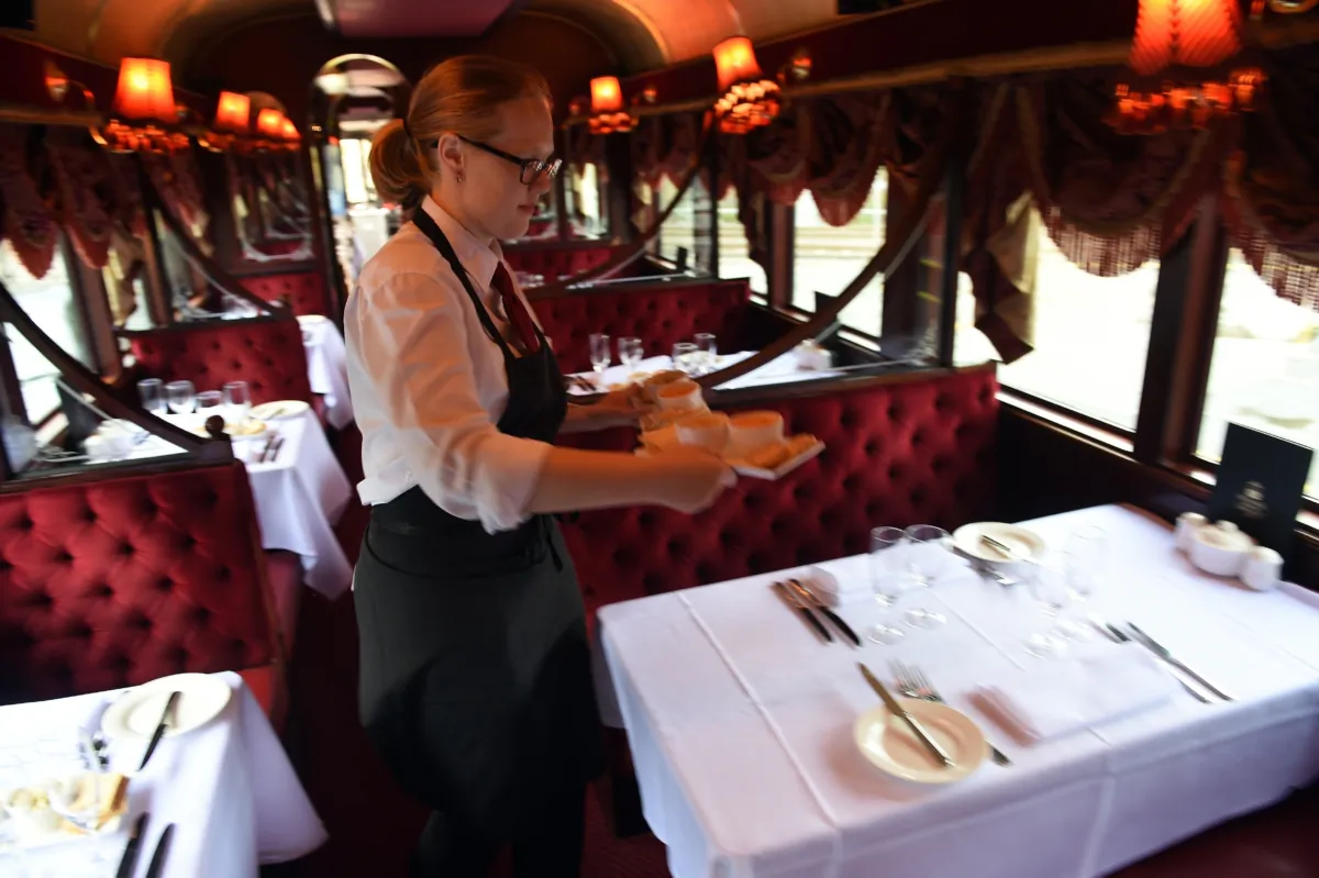 A member of staff prepares the tables in one of the Colonial Tramcar Restaurant vintage trams in Melbourne, Australia, on March 23, 2015. (Indranil Mukherjee/AFP via Getty Images)
