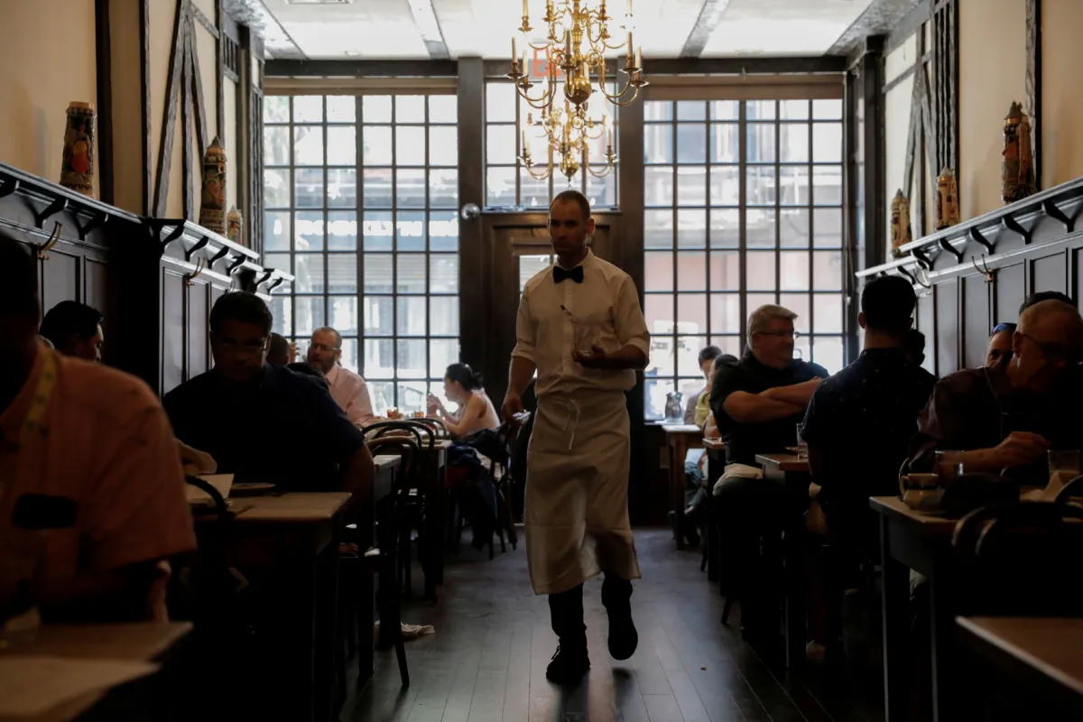 A waiter walks among diners at Peter Luger Steak House in Brooklyn, N.Y., on Aug. 12, 2021. (Andrew Kelly/Reuters)