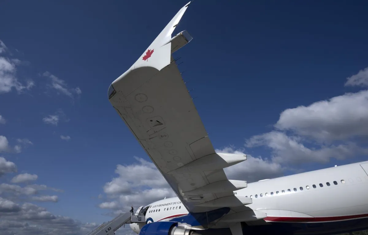 Prime Minister Justin Trudeau waves as he steps off the government plane known as CF001 after arriving at the airport in Riga, Latvia, July 10, 2023. (The Canadian Press/Adrian Wyld)