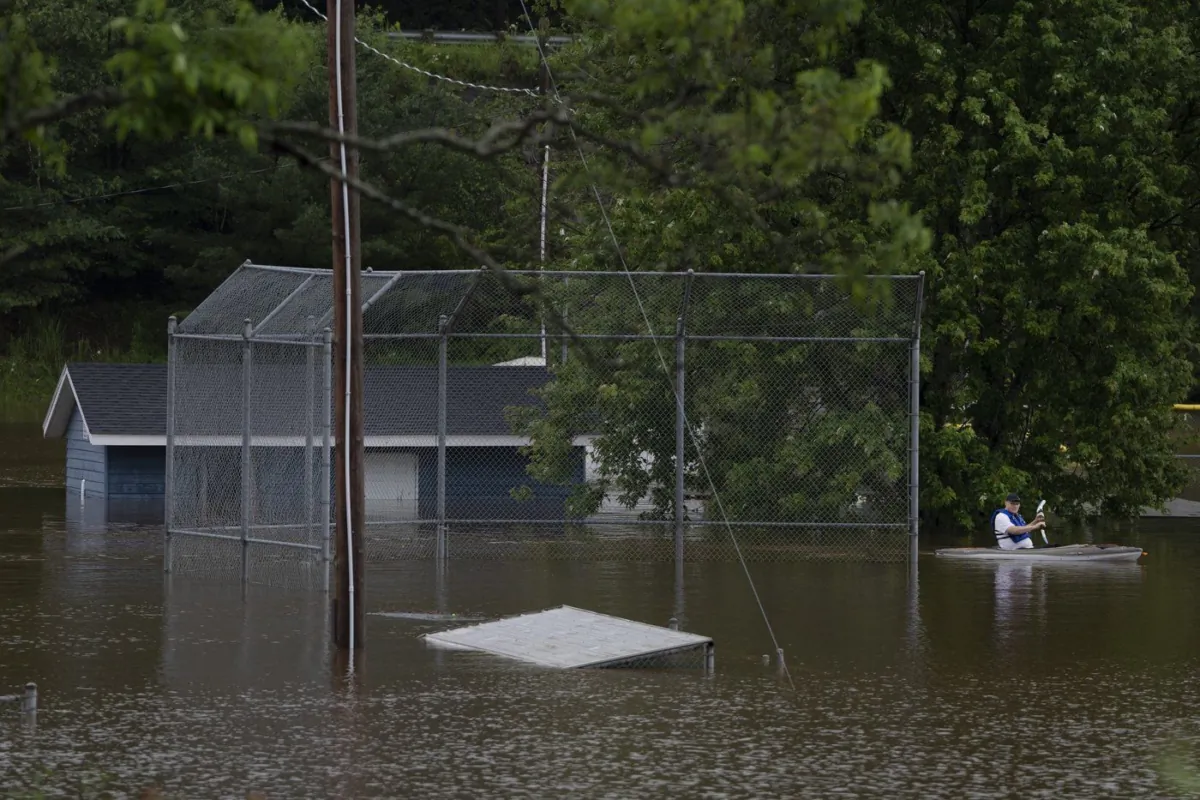 A man paddles a kayak through a flooded baseball diamond following a major rain event in Halifax on July 22, 2023. (The Canadian Press/Darren Calabrese)