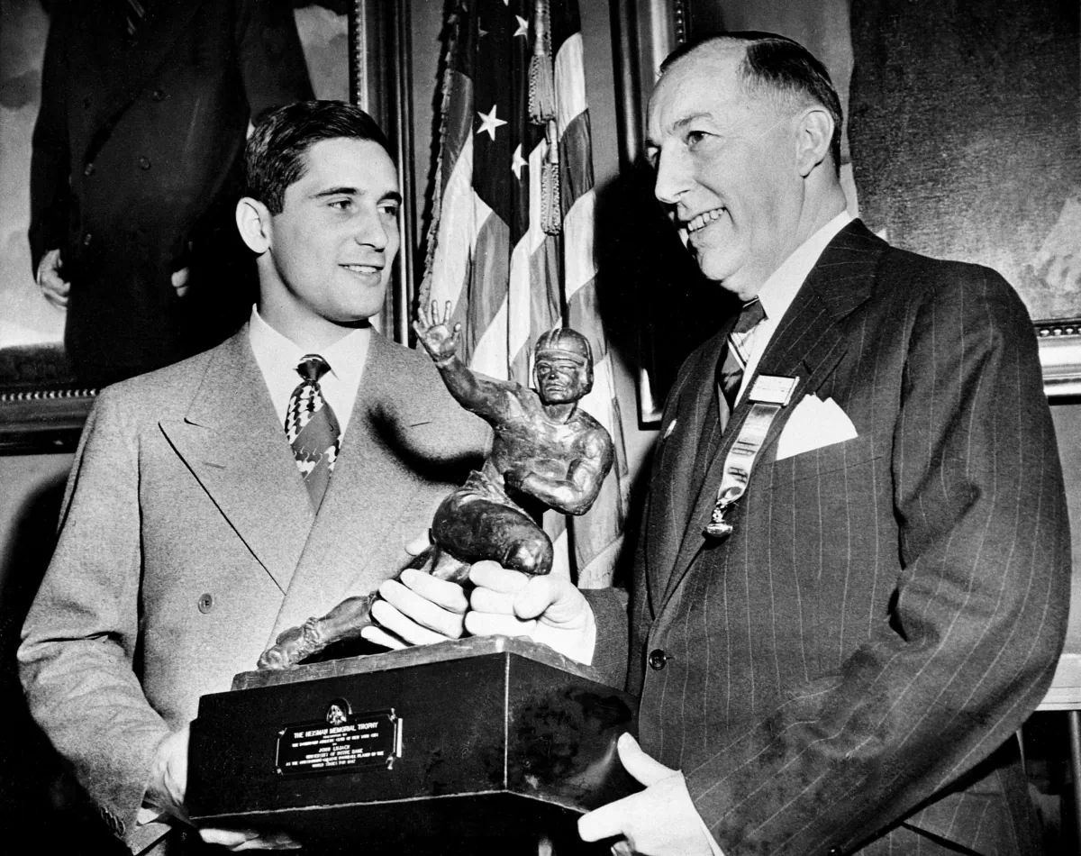 Notre Dame quarterback Johnny Lujack, left, recceives the Heisman Memorial Trophy from Wilbur Jurden, president of the Downtown Athletic Club in New York on Dec. 10, 1947. (Jacob Harris/AP Photo)