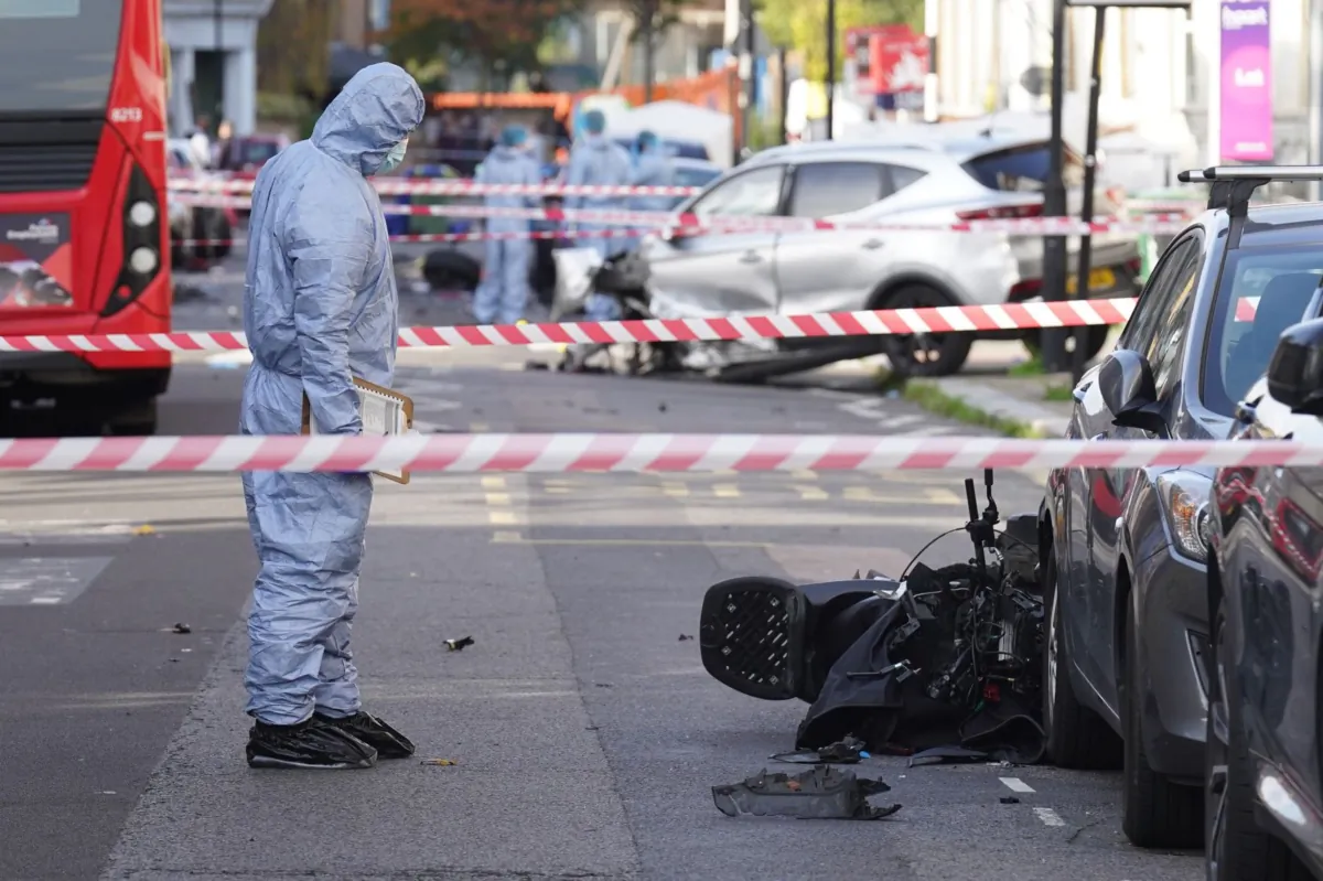 A police forensics officer at the scene of a shooting which killed two people, including Lemar Urquhart, better known as drill artist Perm, in Brixton, south London on Oct. 30, 2022. (PA)