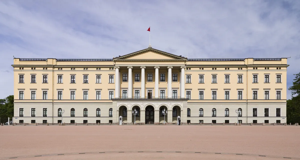 The Royal Palace of Oslo stands tall at the head of the palace’s square. The neoclassical three-story building presents a simple U shape, with two wings, a flat roof, and a façade with stuccoed bricks. A row of six pillars decorates the temple front in a clear reference to classical revival. (Oivind Moller Bakken/The Royal Court)