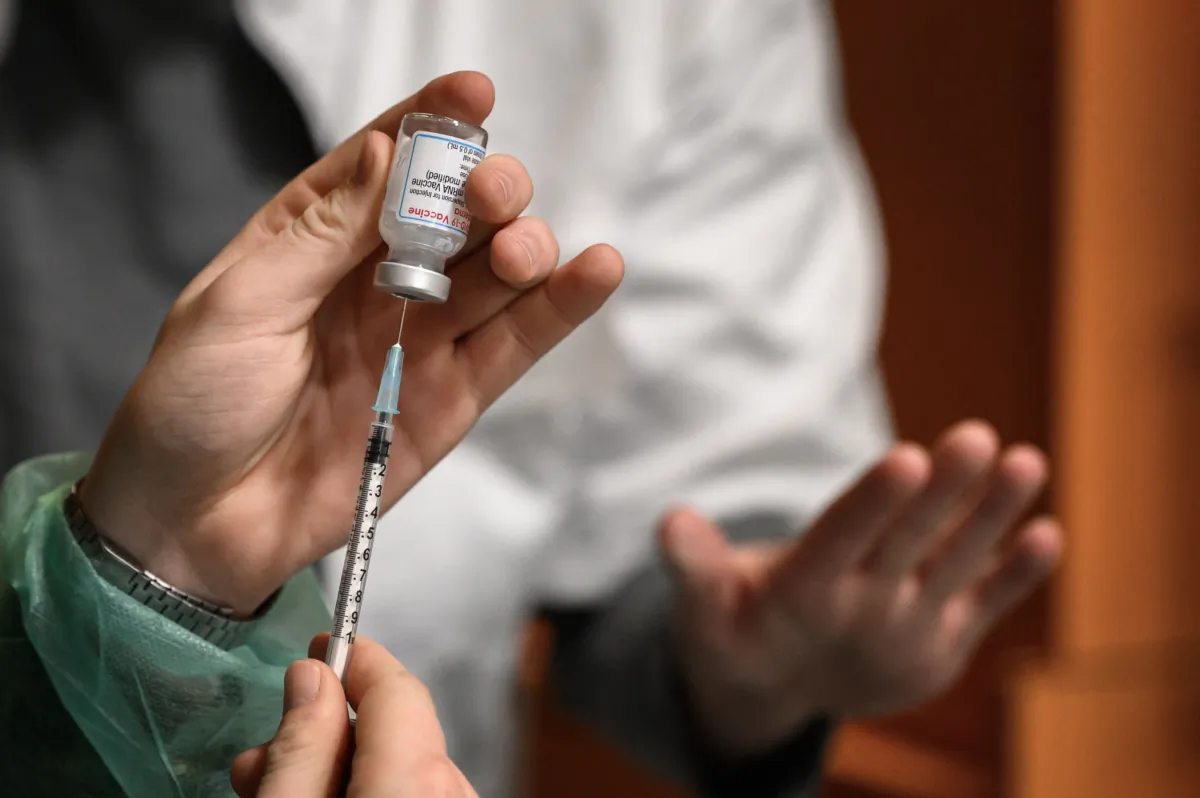 A Swiss soldier fills up a syringe with Moderna Covid-19 vaccine in Delemont, northern Switzerland, on December 14, 2021. - Switzerland hit by a new wave of infections, like much of Europe, has called army in to speed up vaccination. (Photo by Fabrice COFFRINI / AFP) (Photo by FABRICE COFFRINI/AFP via Getty Images)