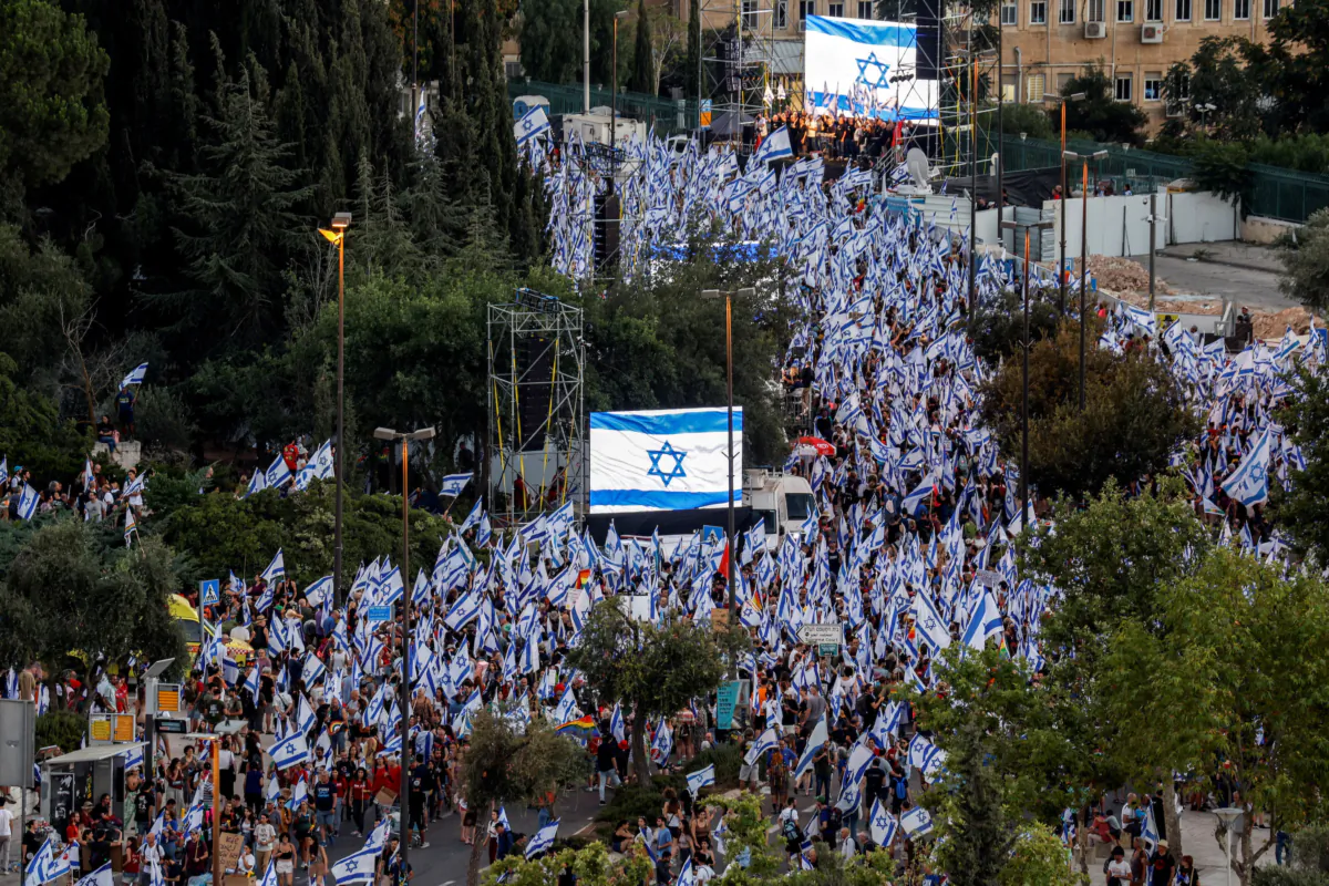 Protesters hold Israeli flags as they demonstrate following the parliament's vote on a contested bill that limits the Supreme Court's powers to void some government decisions, near the Knesset in Jerusalem, on July 24, 2023. (Amir Cohen/Reuters)