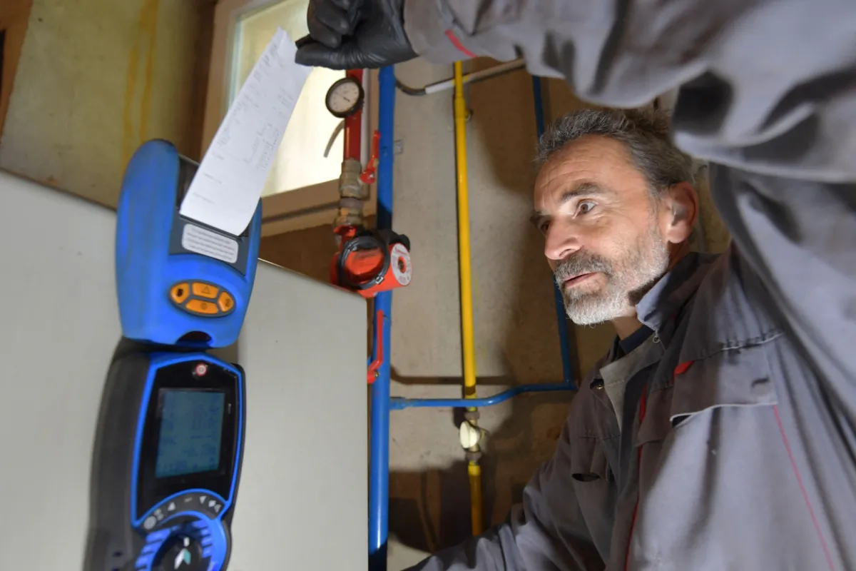 A heating engineer checks a boiler as he is doing an annual natural gas boiler's cleaning, in a file photo. (Jean-Francois Monier/AFP via Getty Images)