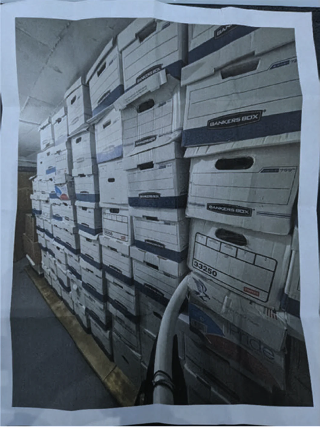 A photo of some of the 61 boxes that federal authorities say were stacked in a storage room at former President Donald Trump's home at Mar-a-Lago. The undated photo was released in court records that were unsealed on July 25, 2023, nearly a year after authorities raided Mr. Trump's home and confiscated documents with classified markings. (Janice Hisle via screenshot of federal court record.)