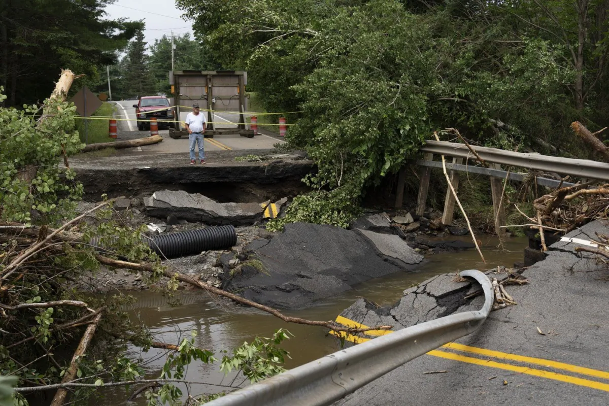 A motorist stops to survey the damage to a washed-out bridge following a major rain event near Newport Corner, N.S. on July 23, 2023. (The Canadian Press/Darren Calabrese)
