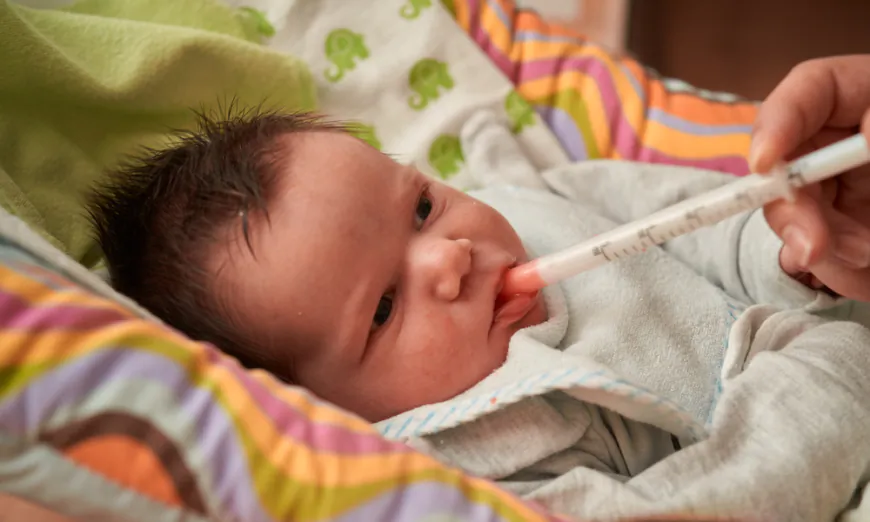 A newborn baby receives oral antibiotics, one of many contributing factors to alterations in the gut microbiome that modulates immunity. (Shutterstock)