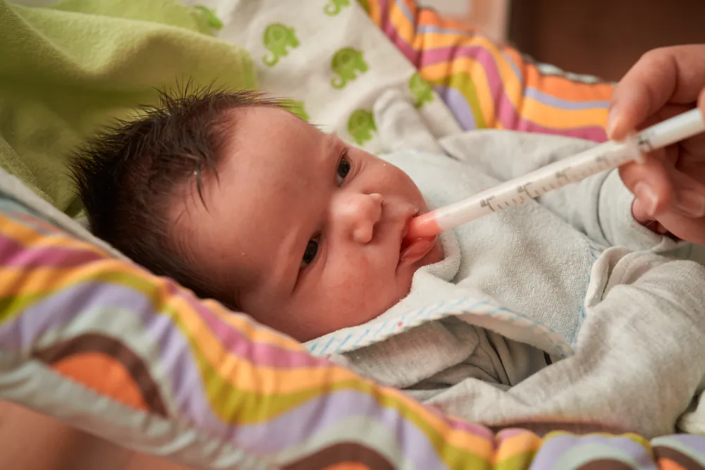 A newborn baby receives oral antibiotics, one of many contributing factors to alterations in the gut microbiome that modulates immunity. (Shutterstock)