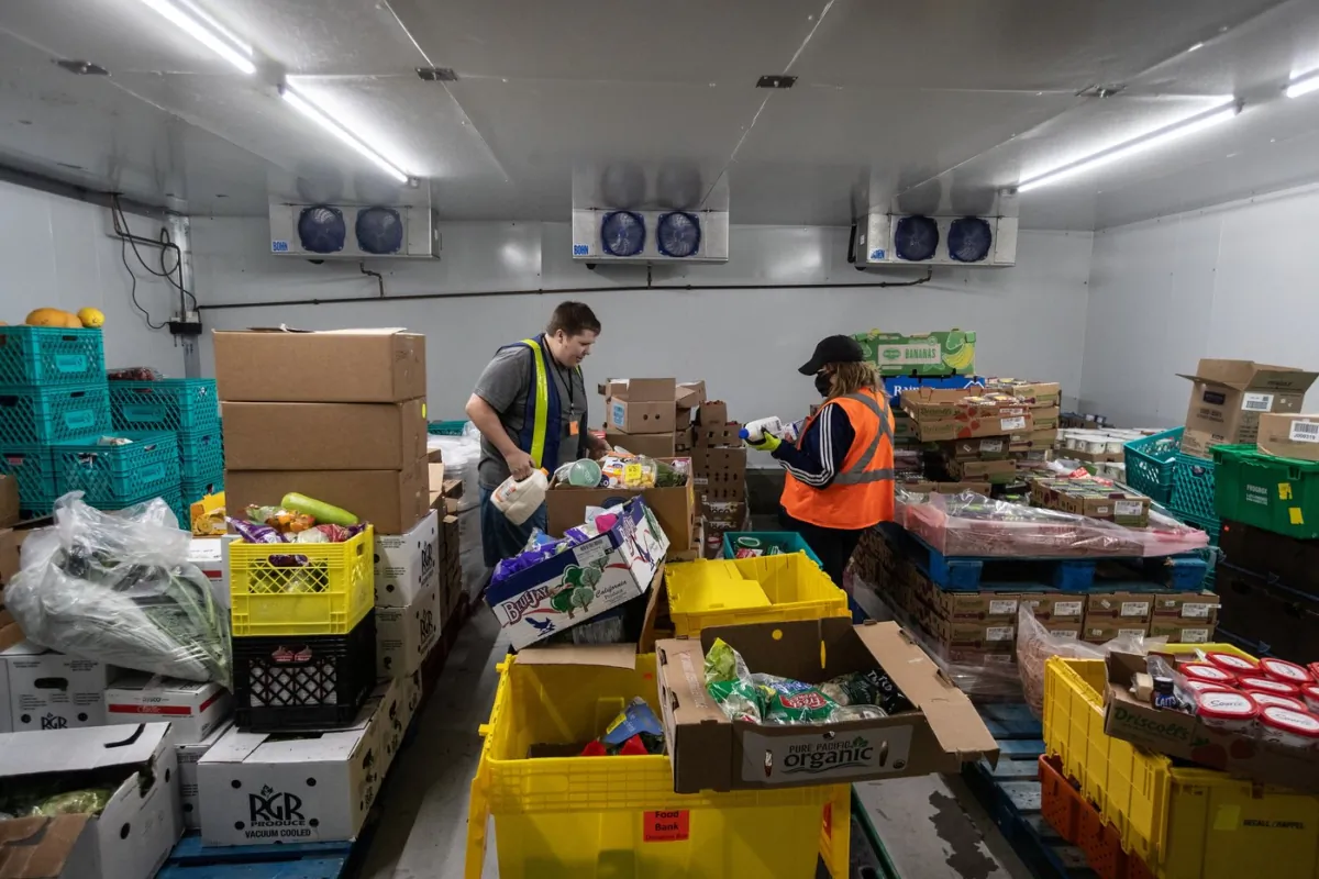 Workers gather food for a homeless mission while at the Edmonton Food Bank, in Edmonton on July 21, 2023. (The Canadian Press/Jason Franson)
