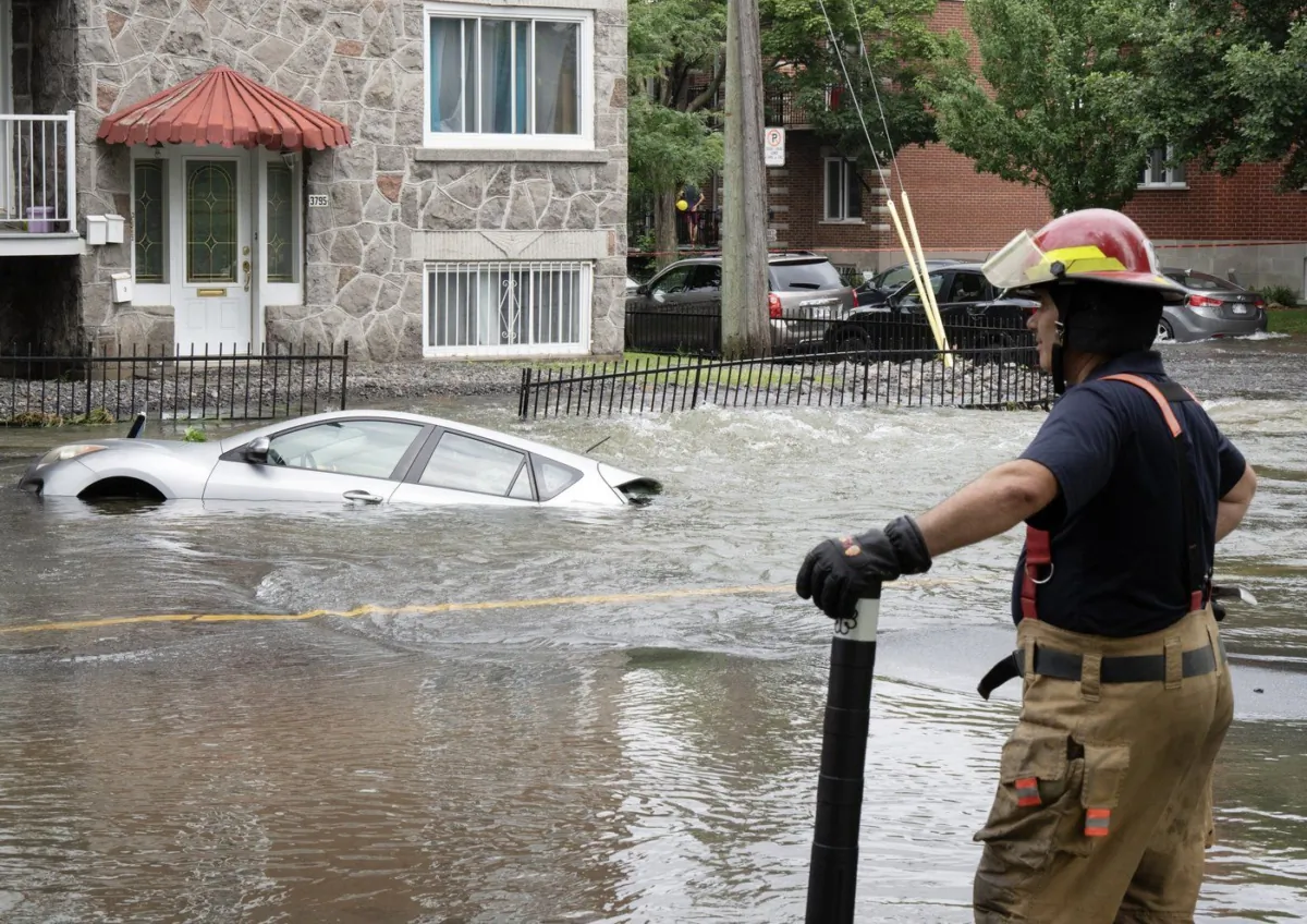 A firefighter surveys the scene after a water main broke and flooded several blocks July 28, 2023, in Montreal. (The Canadian Press/Ryan Remiorz)
