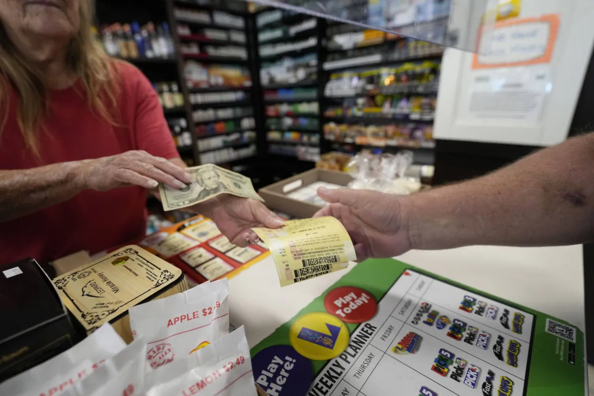 Cashier Rosemary Probst sells tickets for the Mega Millions lottery at the Save 'N Time convenience store in Harahan, La., on July 26, 2023. (Gerald Herbert/AP Photo)
