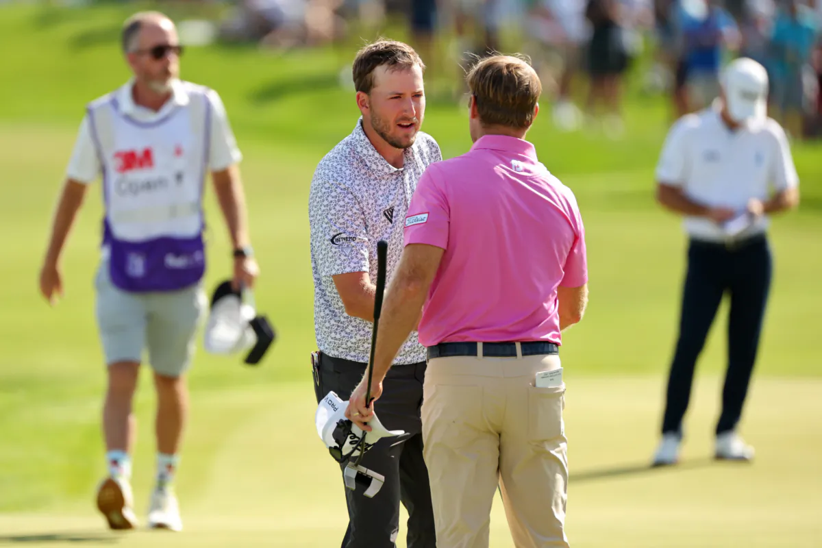 (L-R) Lee Hodges of the United States and Tyler Duncan of the United States shake hands on the 18th green during the third round of the 3M Open at TPC Twin Cities in Blaine, Minn., on July 29, 2023 (Stacy Revere/Getty Images)