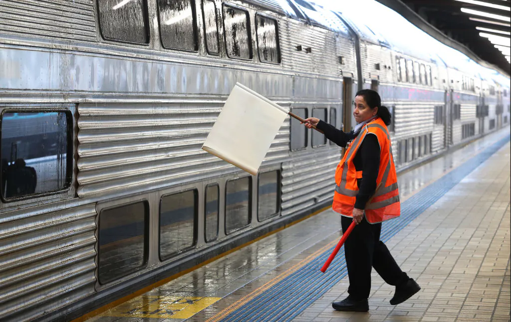 A rail worker signals a train driver at Central railway station in Sydney, Australia, on Oct. 17, 2022. (Lisa Maree Williams/Getty Images)