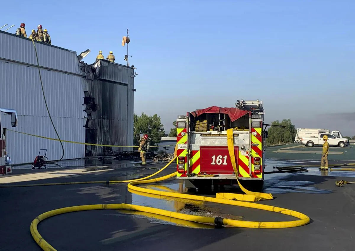 Fire department personnel respond to a small plane that crashed into a hanger at Cable Airport in Upland, Calif., on July 30, 2023. (San Bernardino County Fire Department via AP)