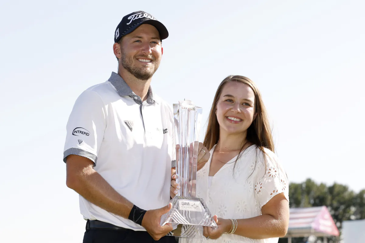 Lee Hodges of the United States celebrates with the trophy alongside wife Savannah Hodges after winning the 3M Open at TPC Twin Cities in Blaine, Minn., on July 30, 2023. (David Berding/Getty Images)