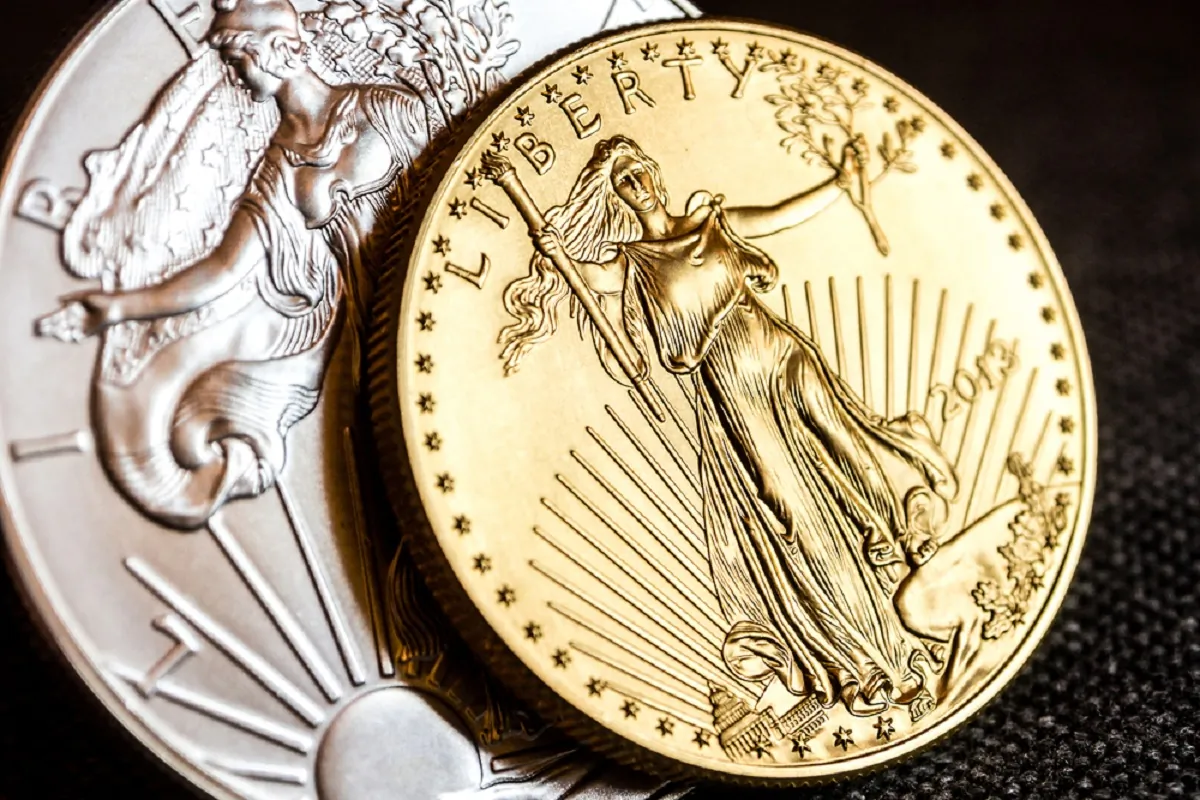 Closeup of Silver Eagle and Golden American Eagle 1 oz. coins on black background. (Jan_S/shutterstock)