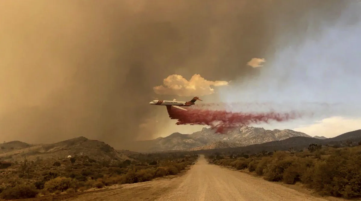 A tanker is making a fire retardant drop over the York fire in Mojave National Preserve, Calif., on July 29, 2023. (Park Ranger R. Almendinger/InciWeb/National Park Service Mojave National Preserve via AP)