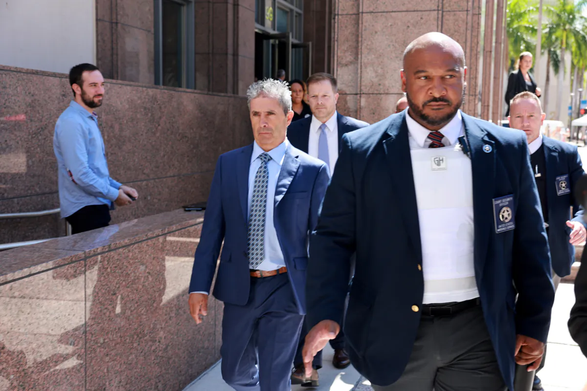 Carlos De Oliveira (C), a property manager for President Donald Trump's Mar-a-Lago estate, leaves the James Lawrence King Federal Justice Building with his lawyer John Irving trailing behind, in Miami, Fla., on July 31, 2023. (Joe Raedle/Getty Images)