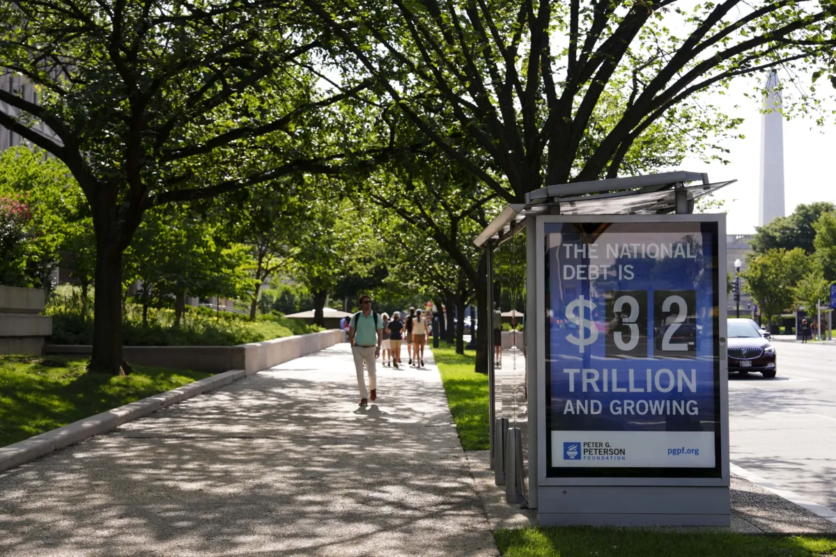The National Debt Clock is seen at a bus stop in Washington on July 31, 2023. (Madalina Vasiliu/The Epoch Times)