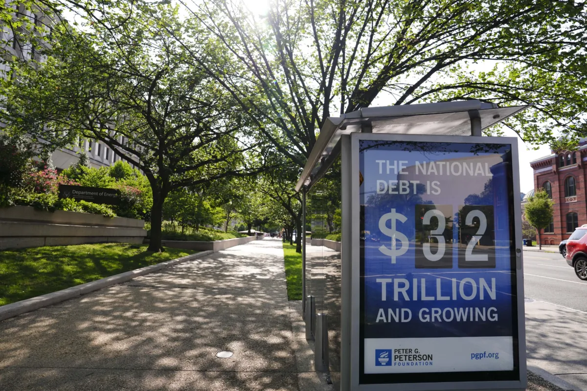 The National Debt Clock is seen at a bus stop in Washington on July 31, 2023. (Madalina Vasiliu/The Epoch Times)