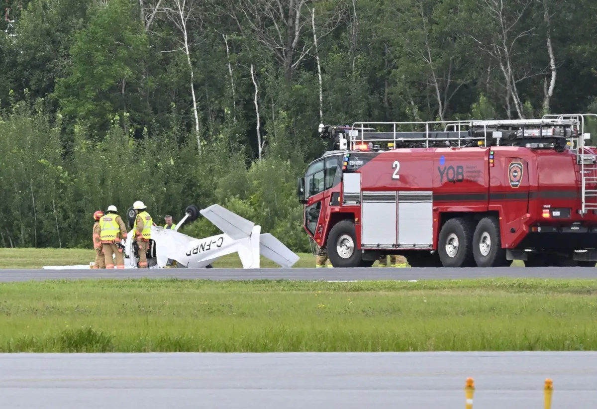 Firefighters look over a Cessna 152 aircraft after it crashed on landing at the Jean Lesage International Airport on Aug. 1, 2023, in Quebec City. (The Canadian Press/Jacques Boissinot)
