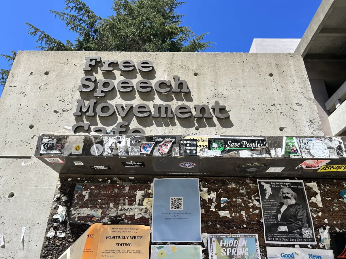 A flyer with an image of Karl Marx can be seen on the wall below the sign of the Free Speech Movement Cafe in Berkeley, Calif., on July 30, 2023. (Courtesy of Loretta Breuning)