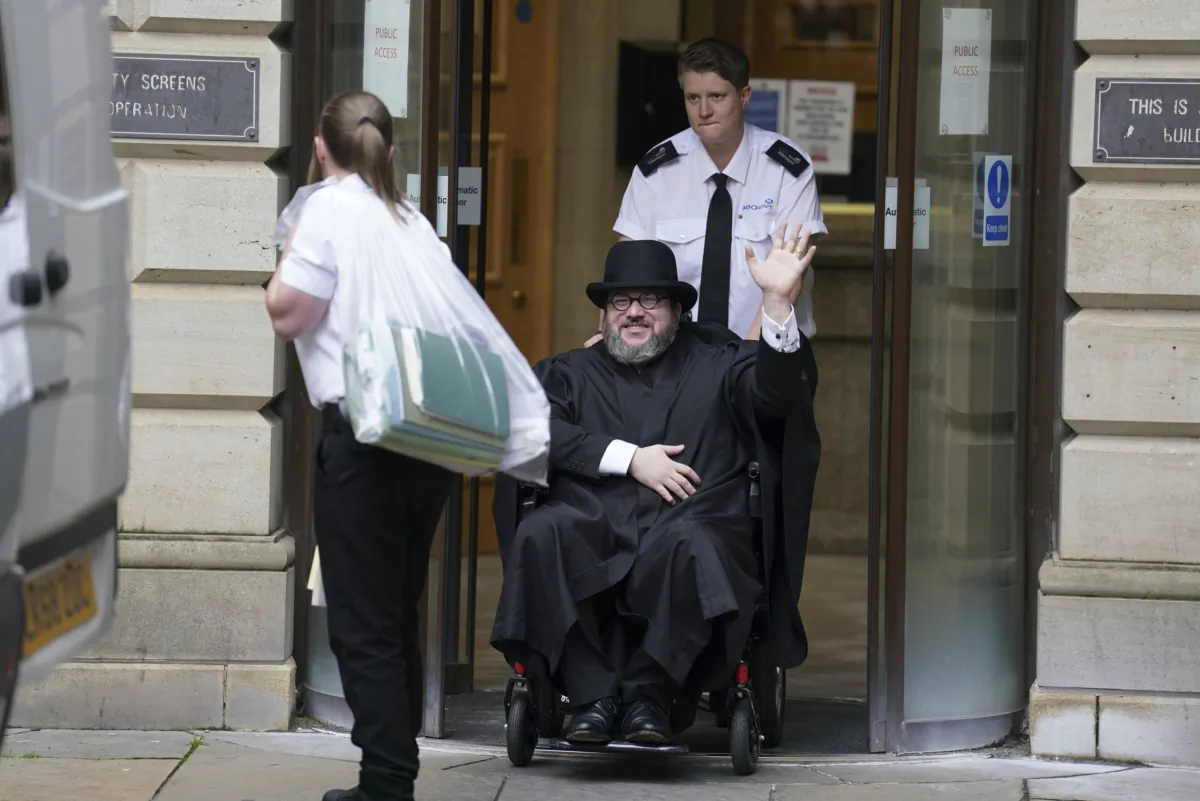 Nicholas Rossi from the United States waves as he leaves the Edinburgh Sheriff and Justice of the Peace Court in Edinburgh, Scotland, on July 12, 2023. (Andrew Milligan/PA via AP)