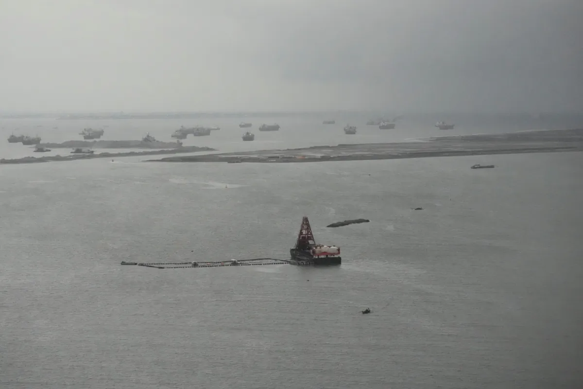 Barges beside reclamation sites in the rain in Manila Bay, Philippines, on Aug. 2, 2023. (AP Photo/Aaron Favila)