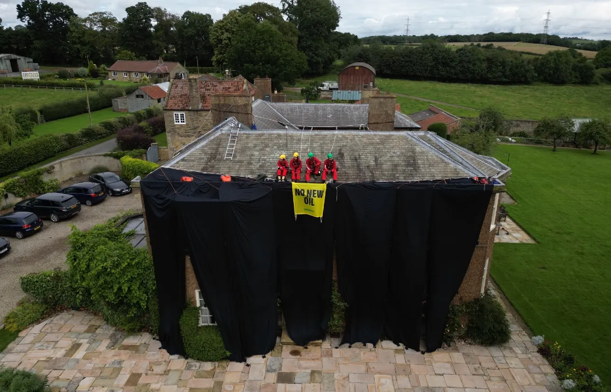 Greenpeace activists on the roof of Prime Minister Rishi Sunak's house in Richmond, North Yorkshire after covering it in black fabric in protest at his backing for expansion of North Sea oil and gas drilling on Aug. 3, 2023. (PA Media)