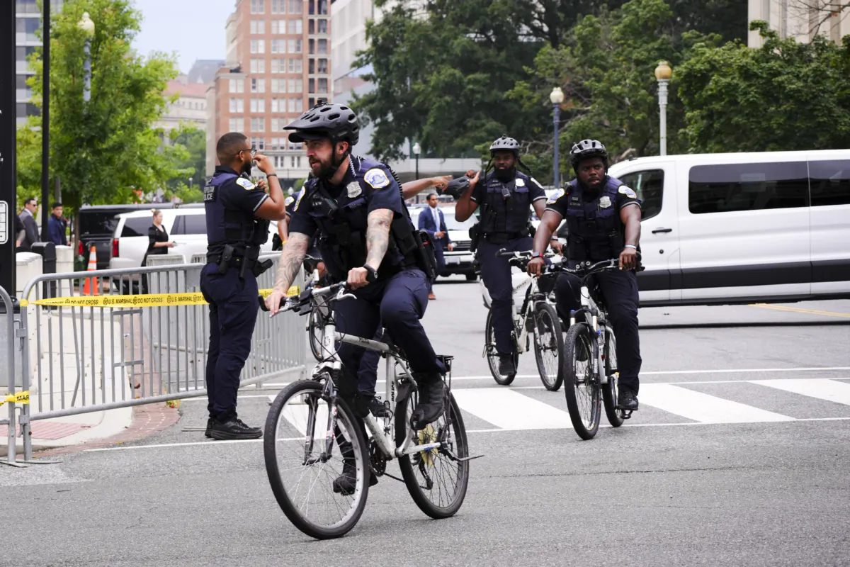 Metropolitan Police officers ride their bikes as former President Donald Trump’s motorcade arrives at E. Barrett Prettyman federal courthouse in Washington on Aug. 3, 2023. (Madalina Vasiliu/The Epoch Times)