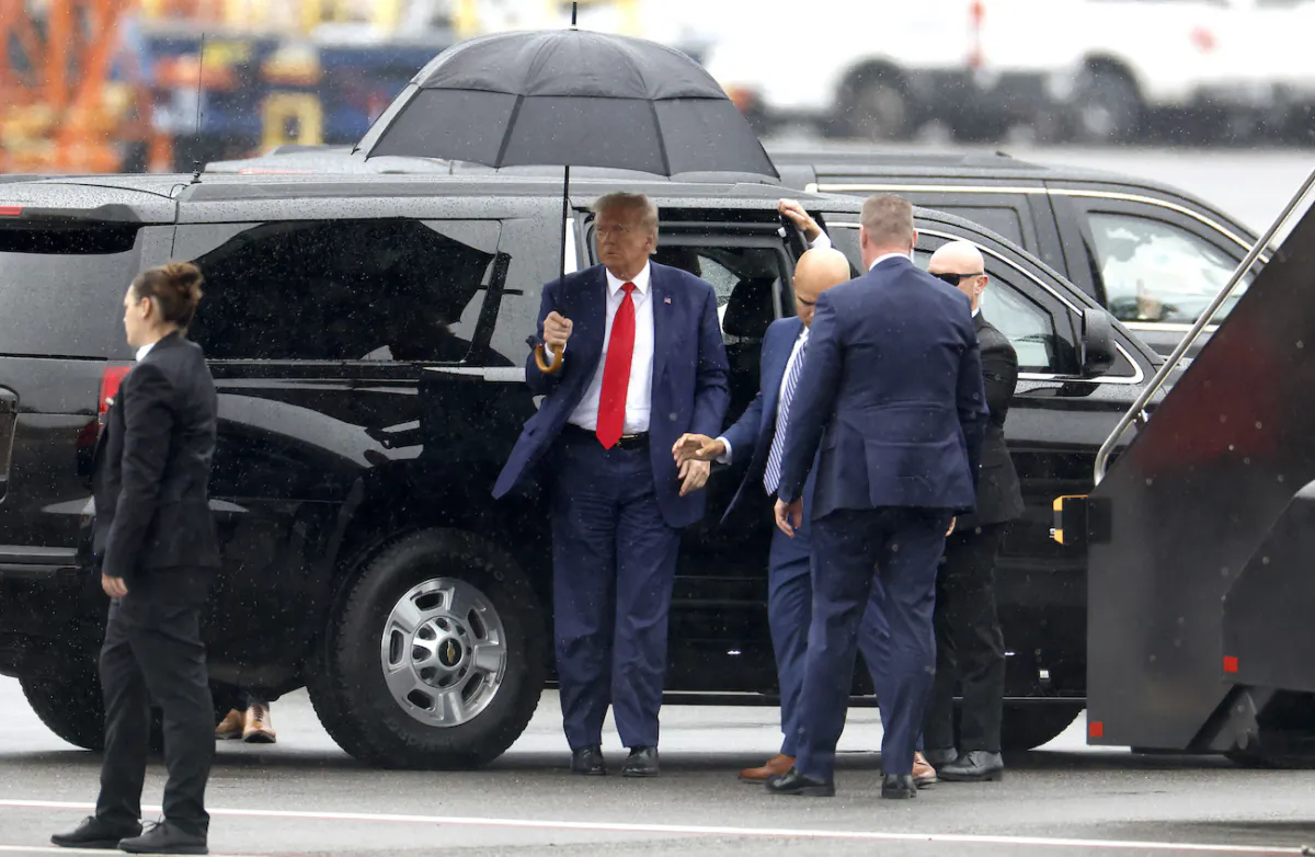 Former U.S. President Donald Trump holds an umbrella as he arrives at Reagan National Airport following an arraignment in a Washington, D.C., court in Arlington, Virginia, on Aug. 3, 2023. (Tasos Katopodis/Getty Images)