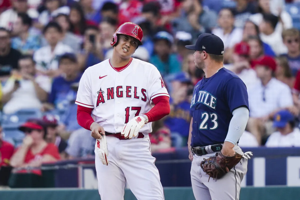 Los Angeles Angels' Shohei Ohtani (17) talks to Seattle Mariners first baseman Ty France (23) after hitting a single during the first inning of a baseball game in Anaheim, Calif., on Aug. 3, 2023. (Ryan Sun/AP Photo)