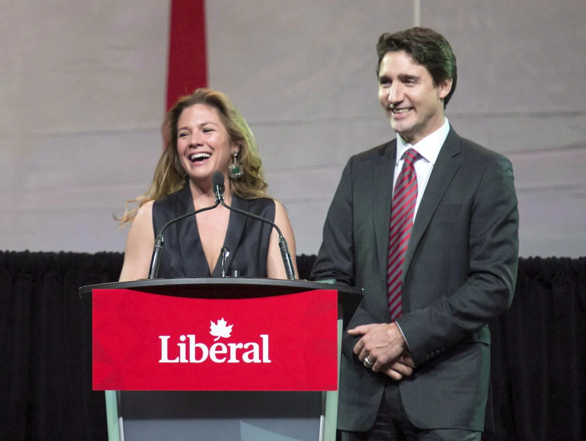 Sophie Grégoire Trudeau speaks at the National Caucus Holiday Party as her husband Prime Minister Justin Trudeau looks on, at the Shaw Centre in Ottawa on Dec. 9, 2015. (The Canadian Press/Justin Tang)