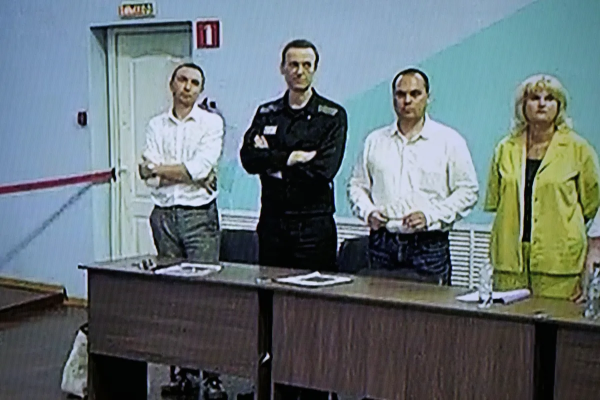 Russian opposition leader Alexei Navalny (2nd L) is seen on a TV screen standing among his lawyers, as he appears in a video link provided by the Russian Federal Penitentiary Service, during a hearing in the colony, in Melekhovo, Vladimir region, about 260 kilometers (163 miles) northeast of Moscow, Russia, on Aug. 4, 2023. (Alexander Zemlianichenko/AP Photo)
