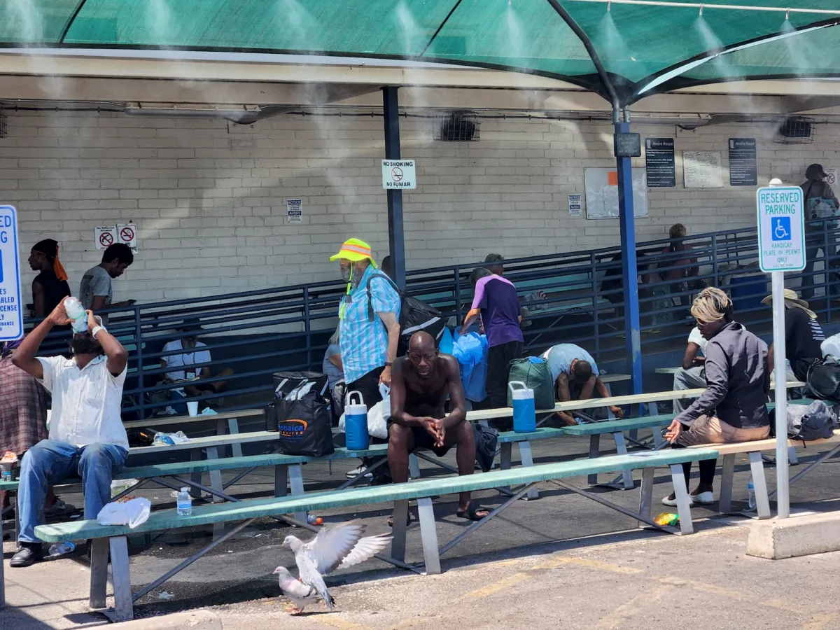 Homeless residents in Phoenix, Ariz., take shelter from 109-degree temperatures sitting under a mist sprayer on Aug. 3, 2023. (Allan Stein/The Epoch Times)